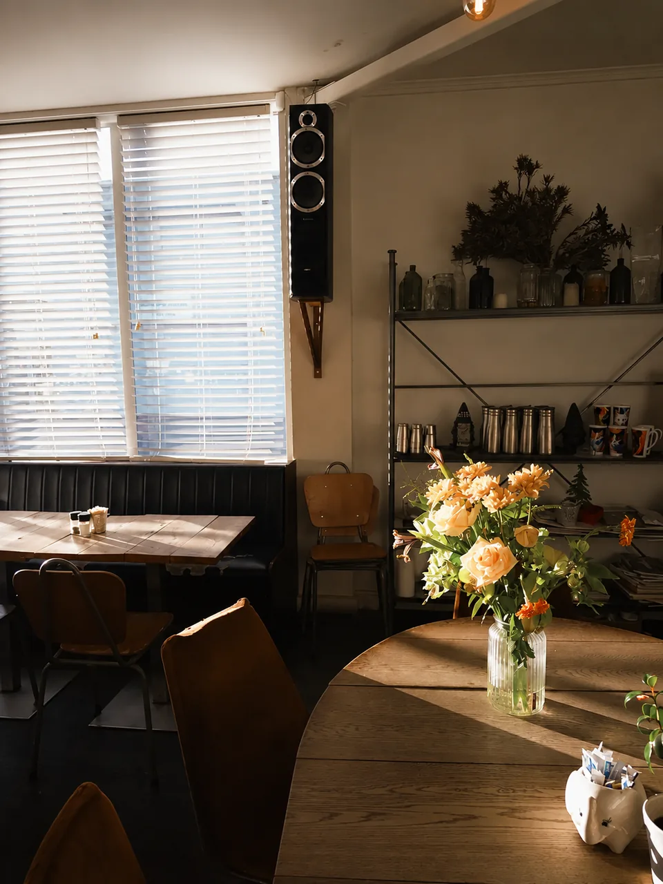 Flowers on a sunlit table beside the cafe window