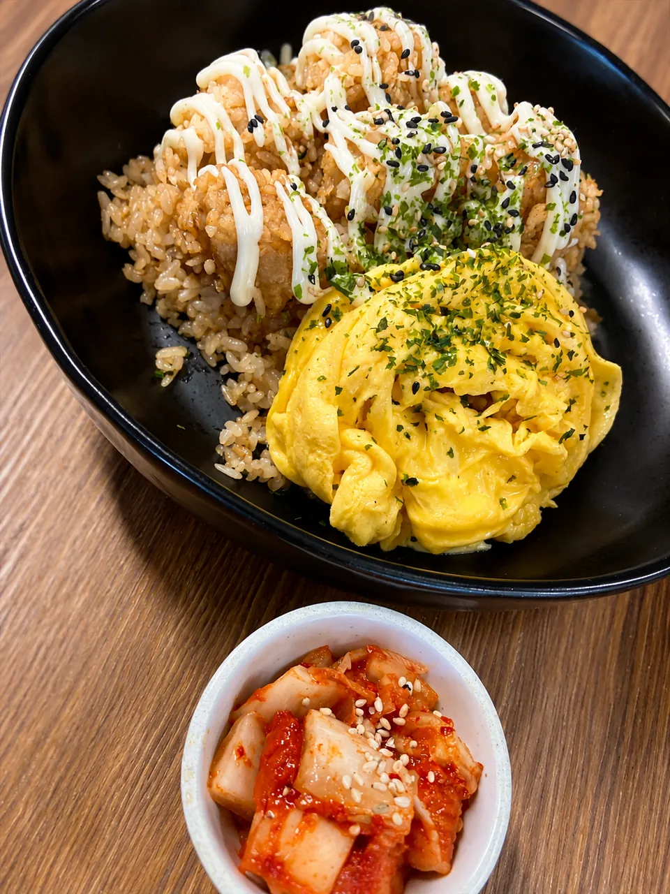 Chicken, fried rice and scrambled eggs with kimchi alongside